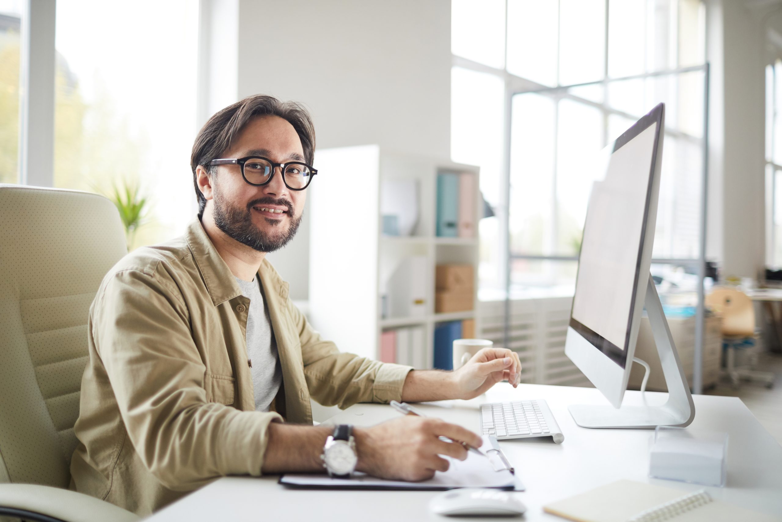 Ein Mann mit Brille die am Computer arbeitet